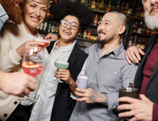 smiling multiethnic colleagues holding glasses with alcohol drinks while spending time in bar smiling multiethnic colleagues holding glasses with alcohol drinks while spending time in bar